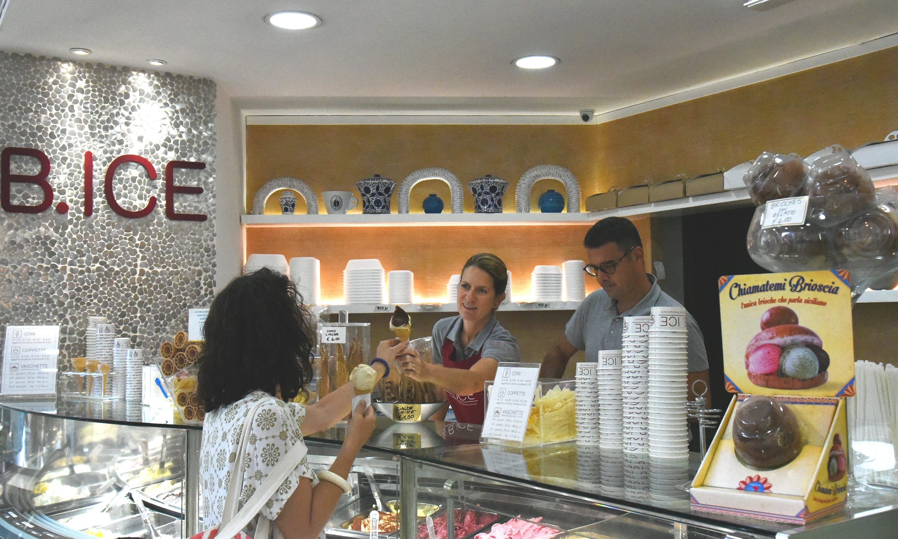The owners of the gelateria B.ICE, Cristina and Aldo, serving a gelato to a client 